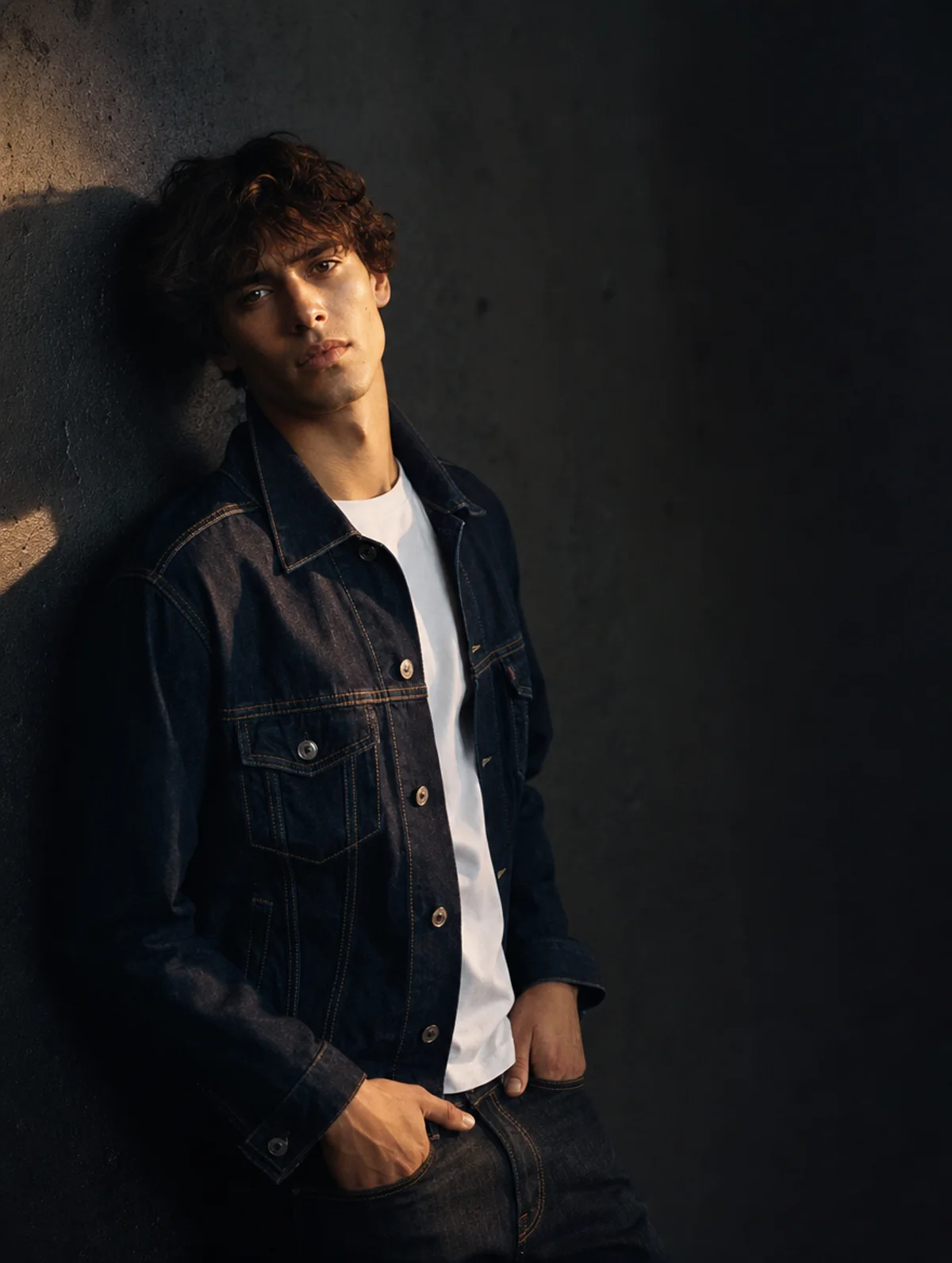 Generated fashion campaign still of a model in an indigo denim jacket